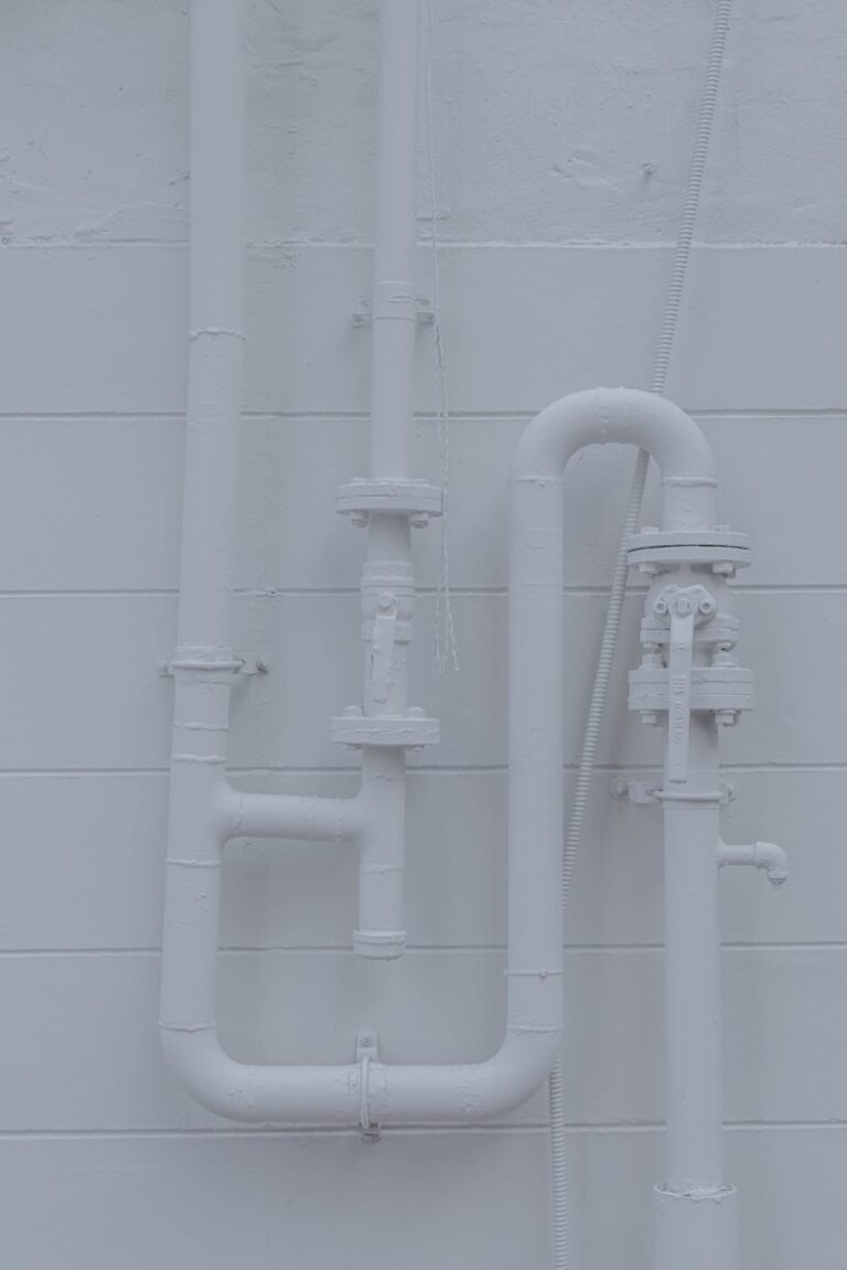 a white wall with pipes attached to it