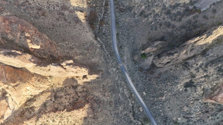 Erdkabel verlegen ohne Graben: Die saubere Alternative zum Bagger Aerial view of a narrow road through rocky desert terrain.